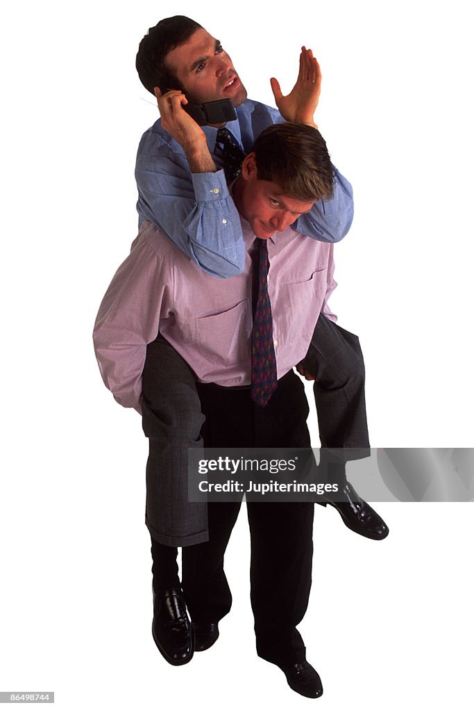 Businessman giving piggyback ride to businessman