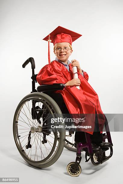 boy in wheelchair wearing cap and gown - graduation gown stock pictures, royalty-free photos & images
