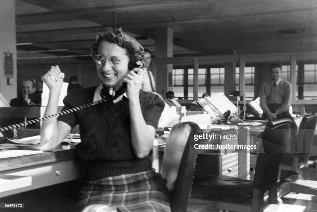 Vintage image of woman using telephone in office