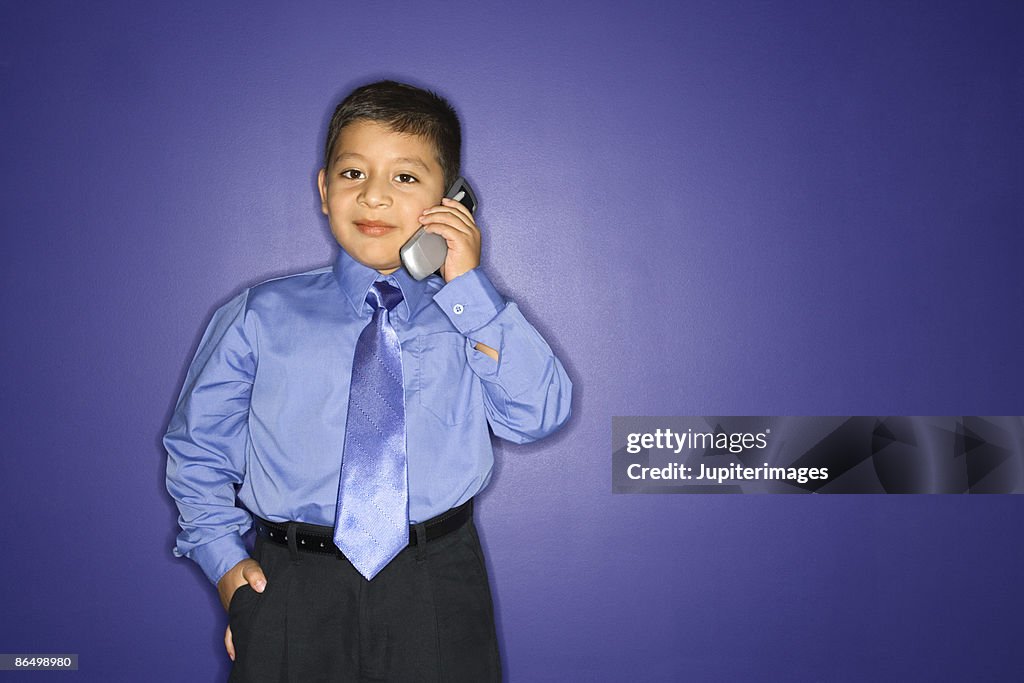 Boy in tie using cell phone