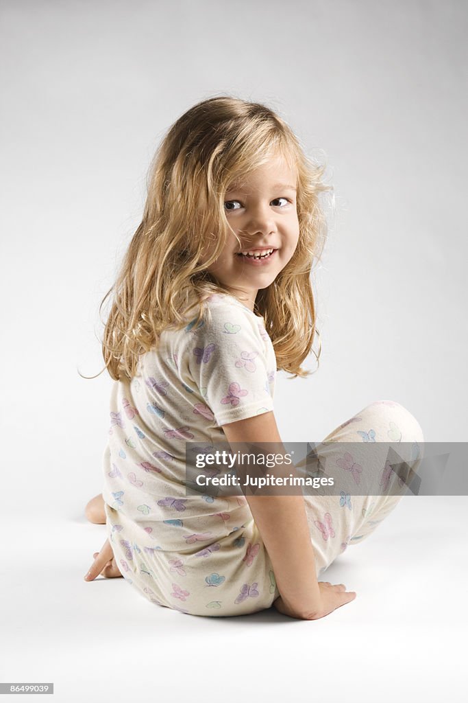 Girl sitting on floor in pajamas