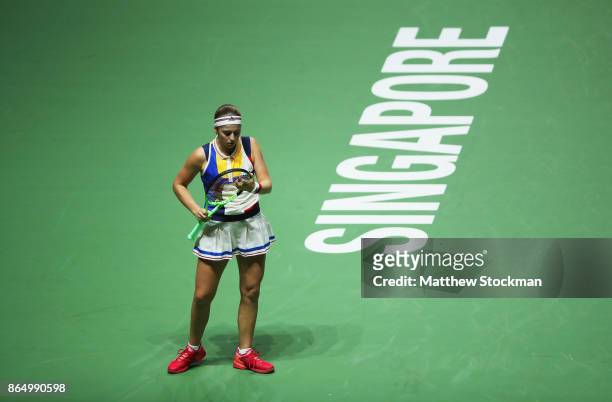 Jelena Ostapenko of Latvia adjusts her racquet between points while playing Garbine Muguruza of Spain during day 1 of the BNP Paribas WTA Finals...