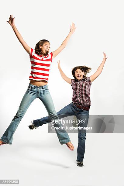 girls jumping in the air - arms akimbo stock pictures, royalty-free photos & images