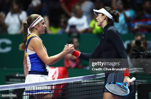 Garbine Muguruza of Spain shakes hands with Jelena Ostapenko of Latvia after her victory during day 1 of the BNP Paribas WTA Finals Singapore...