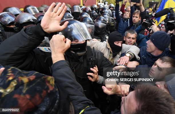 People clash with Ukrainian riot policemen during a demonstration of opposition's supporters in front of the Ukrainian Parliament, in Kiev, on...