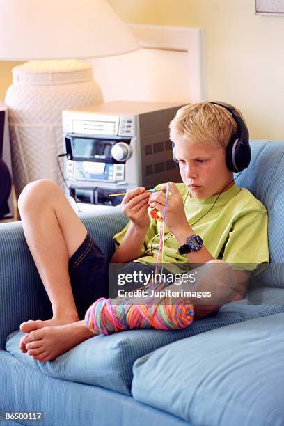 boy listening to music and knitting - boy crocheting stock pictures, royalty-free photos & images