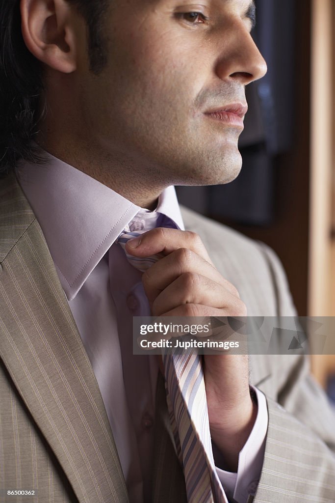 Man adjusting tie