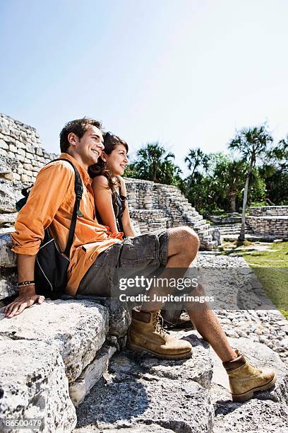 couple sitting on tulum ruins, quintana roo, mexico - mayan ruin stock pictures, royalty-free photos & images