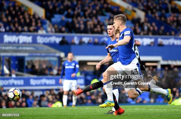 Aaron Ramsey of Arsenal scores his sides fourth goal while under pressure from Phil Jagielka of Everton and Jonjoe Kenny of Everton during the...