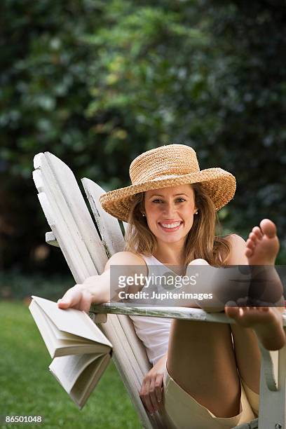 woman relaxing with a book - adirondack chair closeup stock pictures, royalty-free photos & images