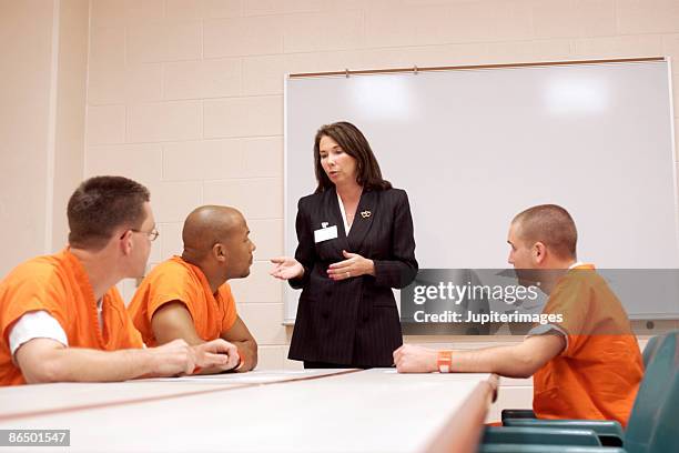 woman talking to inmates - prison uniform stock pictures, royalty-free photos & images