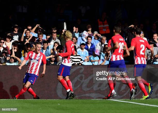 Atletico Madrid's French forward Kevin Gameiro celebrates with teammates after scoring a goal during the Spanish league football match RC Celta de...