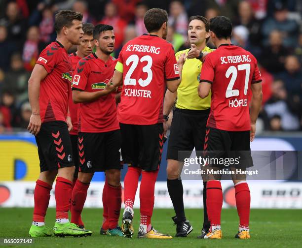 The players of Freiburg discuss with referee Guido Winkmann after the second penalty decission during the Bundesliga match between Sport-Club...