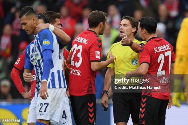 The players of Freiburg discuss with referee Guido Winkmann after the second penalty decission during the Bundesliga match between Sport-Club...