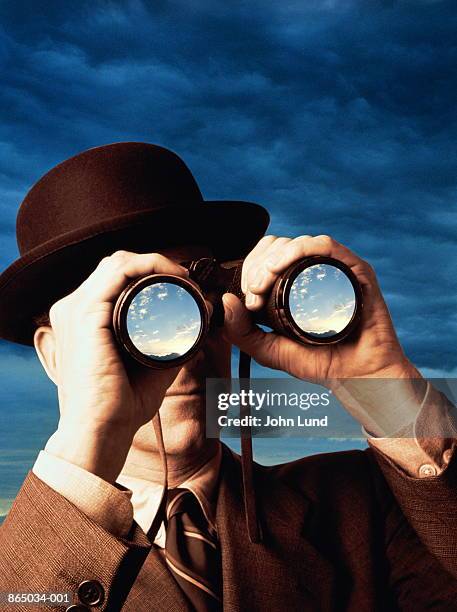 businessman looking through binoculars (digital composite) - binoculars imagens e fotografias de stock