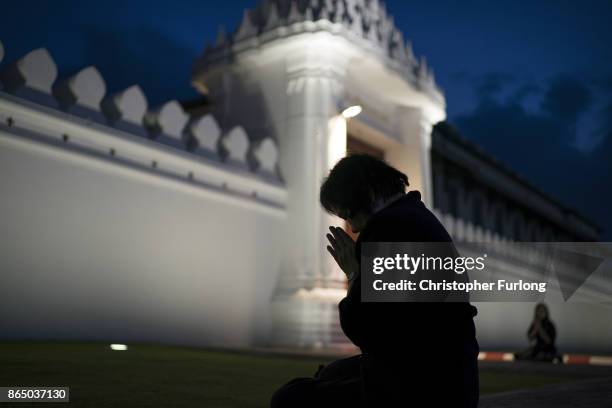 People gather, outside the royal palace, to pay their respects to Thailand's late King Bhumibol Adulyadej as the city prepares for his cremation on...