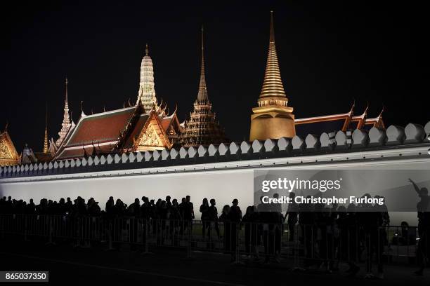 People gather, outside the Grand Palace, to pay their respects to Thailand's late King Bhumibol Adulyadej as the city prepares for his cremation on...