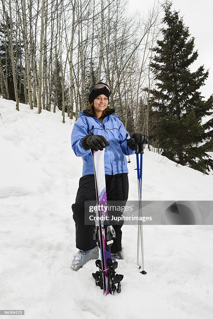 Woman posing with ski equipment