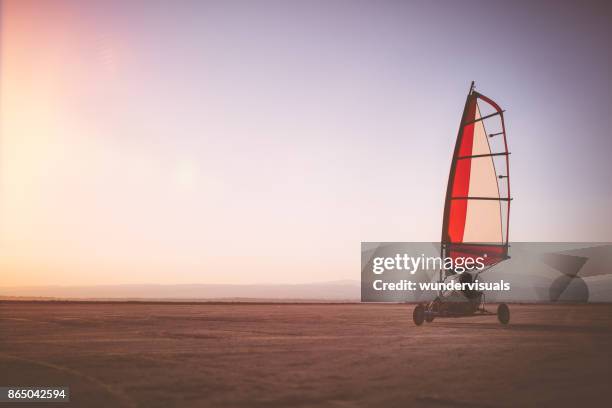 professionele land yachting atleet beoefenen op het strand bij zonsondergang - zeilwagen stockfoto's en -beelden