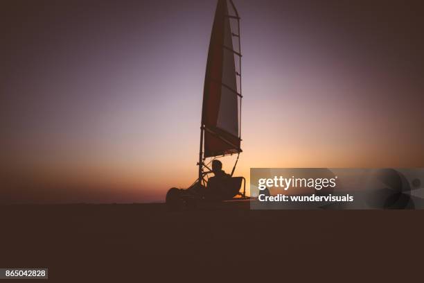 land zeilen atleet beoefenen van de extreme sport op het strand - zeilwagen stockfoto's en -beelden