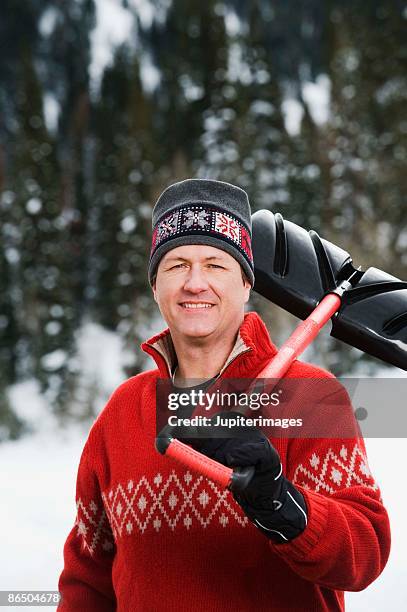 man holding snow shovel - snow shovel man stock pictures, royalty-free photos & images