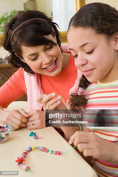 mother and daughter playing with beads - stringing stock pictures, royalty-free photos & images