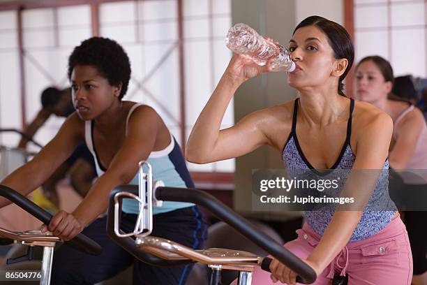 women in exercise class - spin class stock pictures, royalty-free photos & images