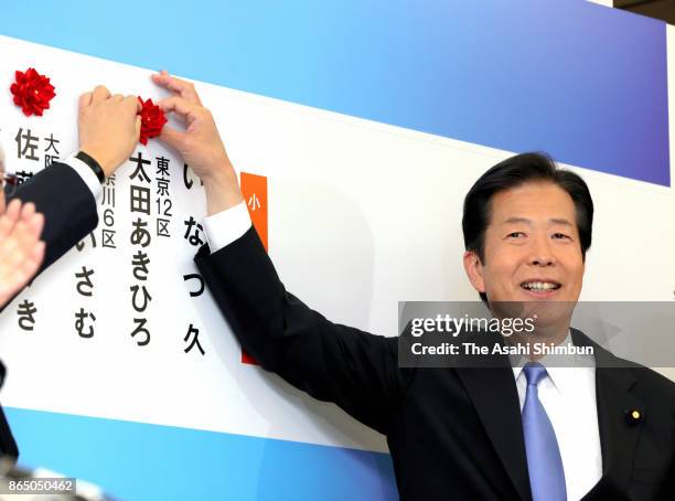 Komeito leader Natsuo Yamaguchi puts a paper rose on the name of winning candidate after the general election on October 22, 2017 in Tokyo, Japan....