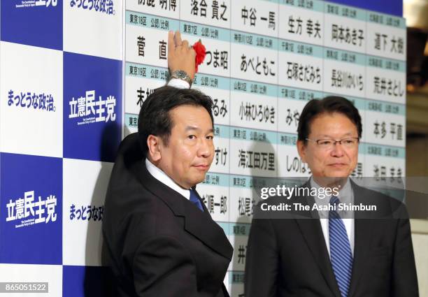 Constitutional Democratic Party of Japan leader Yukio Edano puts a paper rose on the name of the winning candidate after the general election on...