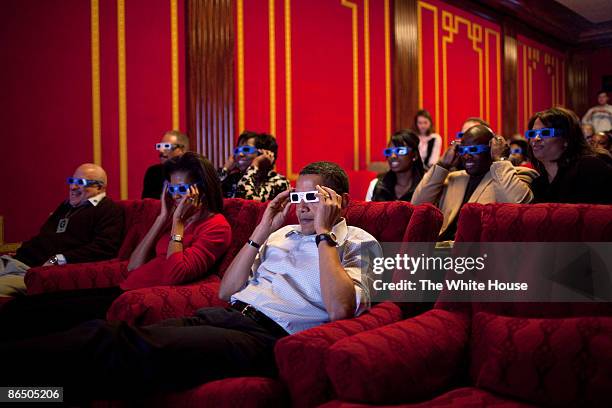 In this handout from the White House, U.S. President Barack Obama and first lady Michelle Obama wear 3-D glasses while watching Super Bowl during a...