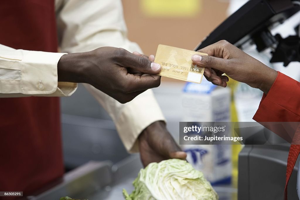 Shopper paying with credit card in market