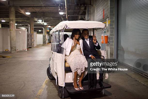 In this handout from the White House, U.S. President President Barack Obama and first lady Michelle Obama ride in a golf cart an Inaugural ball...