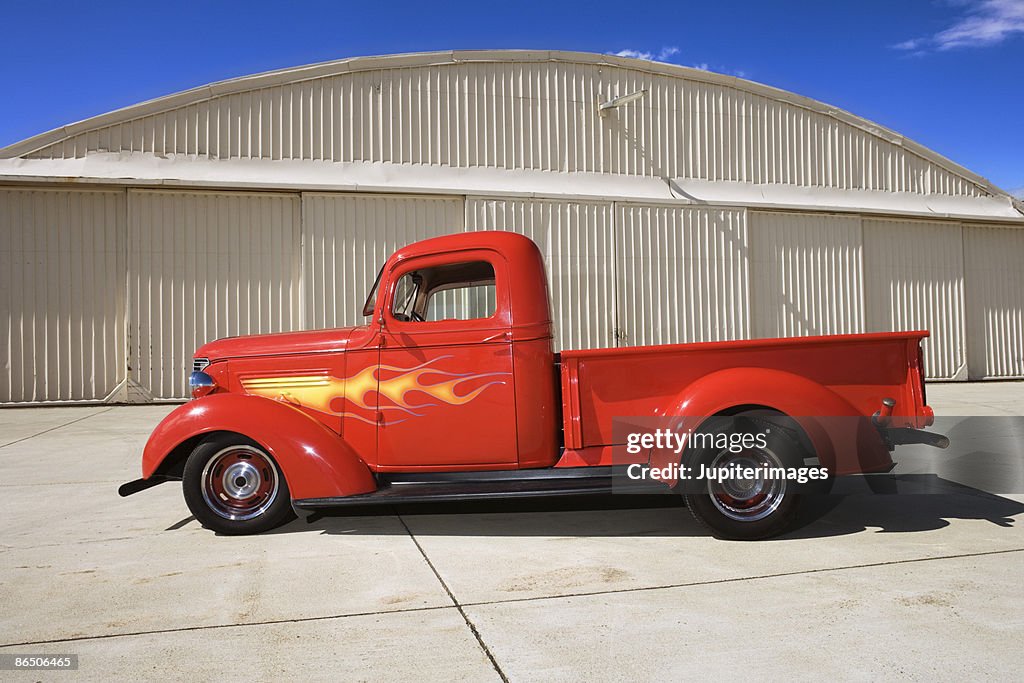 Vintage truck parked next to hangar