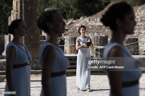Actress Katerina Lechou acting the high priestess holds a pot with the Olympic flame at the Temple of Hera on October 22, 2017 during a dressed...