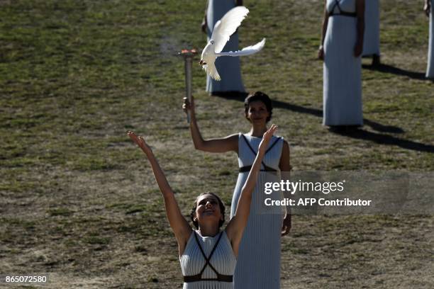 An actress performing as a priestess releases a white dove at the Temple of Hera on October 22, 2017 during a dressed rehearsal of the lighting...