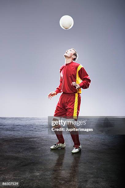 soccer player bouncing soccer ball on head - human head photos et images de collection