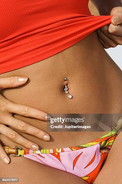 woman with belly button ring - belly ring stock pictures, royalty-free photos & images