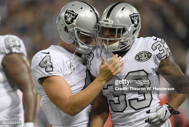 DeAndre Washington of the Oakland Raiders is congratulated by Derek Carr after Washington scored a touchdown against the Kansas City Chiefs during...