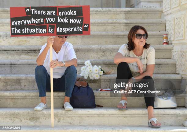 Lady holds up a banner with a quote from murdered Maltese journalist and anti-corruption blogger Daphne Caruana Galizia's blog during a national...