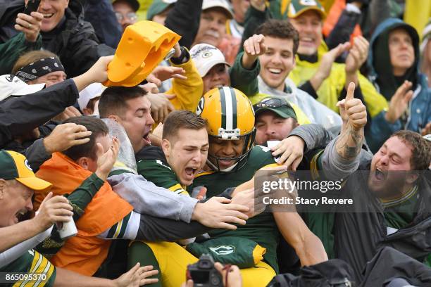 Brett Hundley of the Green Bay Packers celebrates a touchdown with fans during the second quarter against the New Orleans Saints at Lambeau Field on...