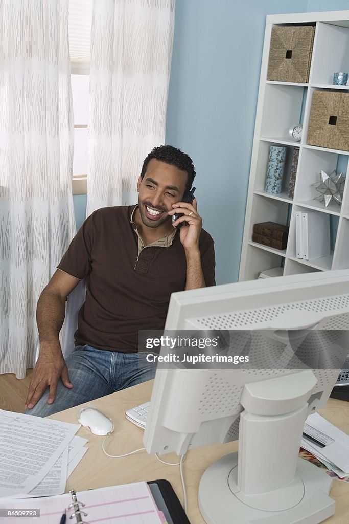 Man with cell phone in home office