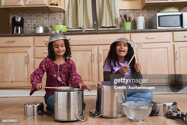 girls drumming on pots and pans in kitchen - hitting drum stock pictures, royalty-free photos & images