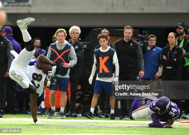 Benjamin Watson of the Baltimore Ravens flip upside down with the ball after taking a hit by Andrew Sendejo of the Minnesota Vikings in the second...