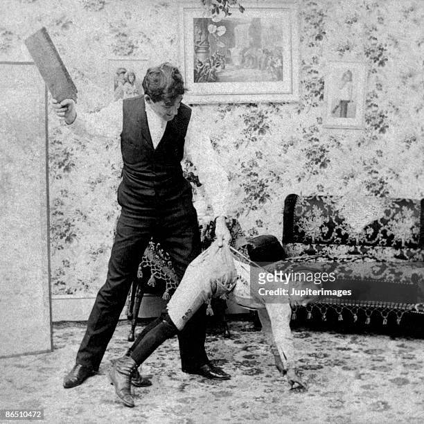 vintage image of man paddling boy - father spanking son bildbanksfoton och bilder