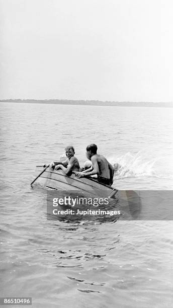 vintage image of boys in capsizing boat - capsizing stockfoto's en -beelden