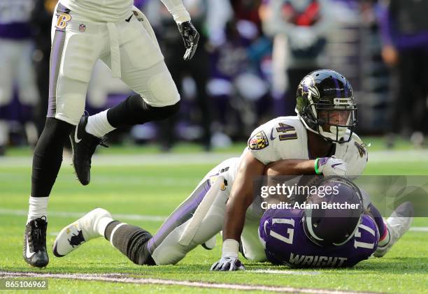 Jarius Wright of the Minnesota Vikings is tacked with the ball by defender Anthony Levine of the Baltimore Ravens in the second quarter of the game...