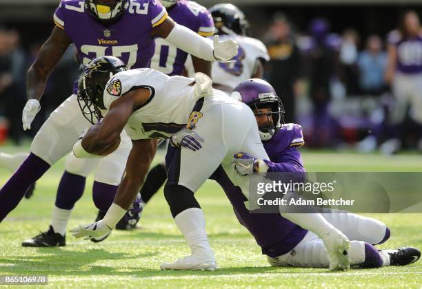 Bobby Rainey of the Baltimore Ravens is tackled by defender Marcus Sherels of the Minnesota Vikings in the second quarter of the game on October 22,...