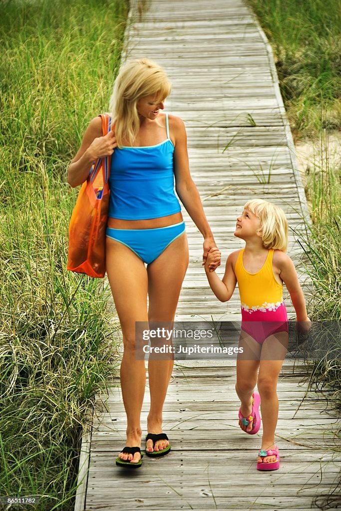 Mother and daughter walking down boardwalk