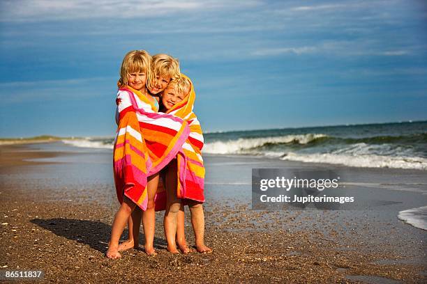 girls wrapped in towel at beach - envuelto en una toalla fotografías e imágenes de stock