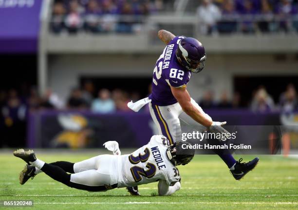 Eric Weddle of the Baltimore Ravens dives to tackle Kyle Rudolph of the Minnesota Vikings with the ball in the first half of the game on October 22,...